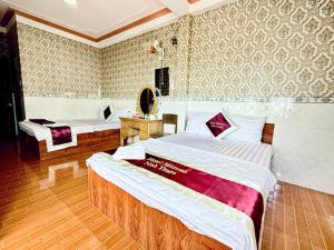une chambre d'hôtel avec deux lits et un miroir dans l'établissement Hotel Mimosa 2, à Phan Rang