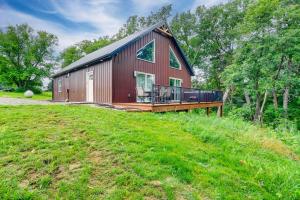 a red barn with a deck on a grass field at Hot Tub, Water Access Cabin Near Lake Red Rock! in Knoxville