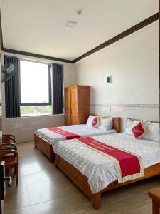une chambre avec deux lits et une fenêtre dans l'établissement Hotel Mimosa 2, à Phan Rang