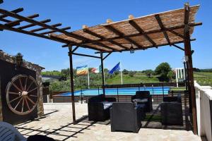 a wooden pergola with chairs and a swimming pool at Il Sogno in Tollo