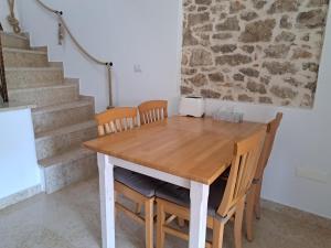 a wooden table and chairs in a room with stairs at Apartment Greta in Funtana