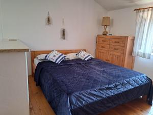 a bedroom with a bed with a blue comforter at Apartment Greta in Funtana +3 photos