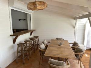 a dining room with a table and stools at L'abri Côtier - Appartement duplex 2 chambres in Le Gosier