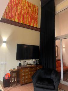 a living room with a flat screen tv and a chair at Domina Coral Bay Harem Luxury in Banī Ghālib