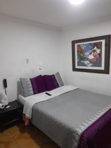 a bedroom with two beds and a picture on the wall at Hotel Parkway Inn 58 Street in Bogotá