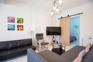 ein Wohnzimmer mit Sofa und Fernseher in der Unterkunft 4Seasonsapts in Agios Nikolaos