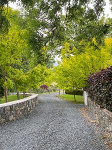 eine Schotterstraße mit Bäumen und einer Steinmauer in der Unterkunft Riverside Cottage in Square