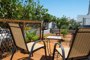 zwei Stühle und ein Tisch auf einem Holzdeck in der Unterkunft 4Seasonsapts in Agios Nikolaos