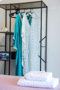 ein Brautkleid und ein blaues Kleid auf einem Ständer in der Unterkunft 4Seasonsapts in Agios Nikolaos + 52 Fotos