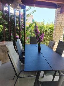 a blue table with a vase of flowers on a patio at House Roko by the sea in Sveti Petar