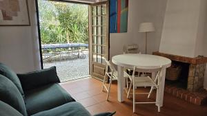 Una sala de estar con una mesa y sillas y un sofá. en Pool Sea & Country side Villa, en Aldeia de São Pedro