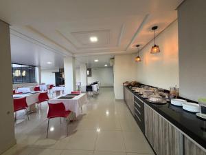 a dining room with tables and chairs and a kitchen at Benni Palace Hotel in Parauapebas +20 photos