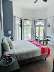 a bedroom with a large bed with a table and windows at The Quetzal in Cancún