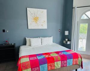 a bedroom with a bed with a colorful blanket at The Quetzal in Cancún