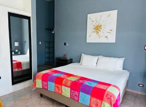 a bedroom with a large bed with a colorful blanket at The Quetzal in Cancún