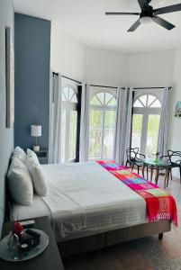 a bedroom with a large bed with a ceiling fan at The Quetzal in Cancún