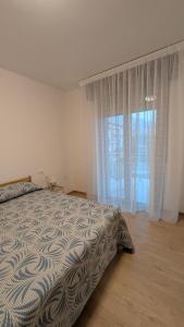 a bedroom with a bed and a large window at Lake Garda Renovated Apartment in Torri del Benaco