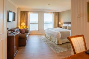a hotel room with a bedroom with a bed and a couch at Cala di Volpe Boutique Hotel in Montevideo