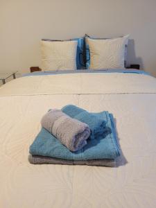 Una pila de toallas sobre una cama en Nowa Apartment, en Wroclaw