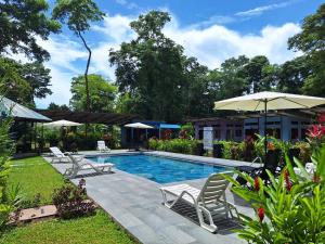 una piscina con sedie e ombrellone di Caribbean Blue Morpho Casitas a Talamanca