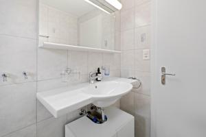 a white bathroom with a sink and a shower at Zermatt 4 pers, 3 lits - vue & calme in Zermatt +25 photos