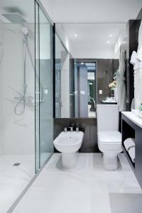 a bathroom with a toilet and a shower and a sink at NH Collection Buenos Aires Crillón in Buenos Aires