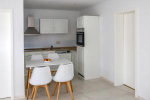 a kitchen with a white table and white chairs at Feriendomizil "Putbus"WE16 in Putbus
