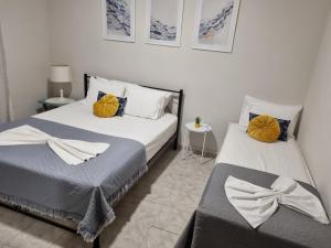 2 camas en un dormitorio con 2 almohadas amarillas en Villa Asteri Luxury Apartment Ouranoupoli, en Ouranoupoli