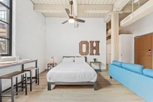 Un dormitorio con una cama y un sofá azul. en Studio at Superior l Downtown l Parking l Café, en Cleveland