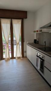 a kitchen with a counter and a window with curtains at Lake Garda Renovated Apartment in Torri del Benaco +39 photos