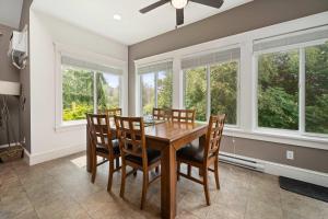 a dining room with a table and chairs and windows at The Pronghorn - 97 Butternut in Cherry Valley