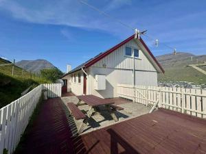 a building with a picnic table on a deck at The Northern Escape in Klaksvík