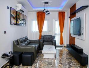a living room with a couch and a flat screen tv at Hôtel Exotic Plaza in Douala