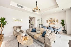 uma sala de estar com um sofá e uma mesa em Damac Hills 2 Poolside no Dubai