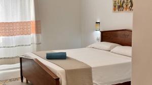a bedroom with a bed with a blue box on it at Hotel Villa Cedrino in Dorgali