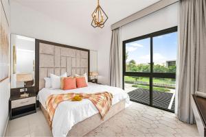 um quarto com uma cama grande e uma janela grande em Damac Hills 2 Poolside no Dubai