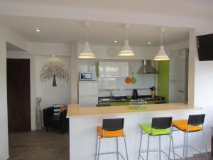 a kitchen with three bar stools and a counter top at Alvor Torralta Apartment in Alvor
