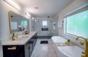 ein Badezimmer mit einer großen Badewanne, einem Waschbecken und einer Badewanne in der Unterkunft Luxury ATL Home Near East Lake Golf & Beltline in Atlanta