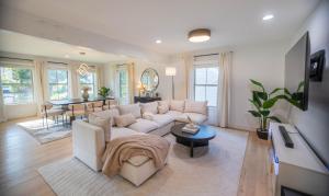 ein Wohnzimmer mit einer weißen Couch und einem Tisch in der Unterkunft Luxury ATL Home Near East Lake Golf & Beltline in Atlanta