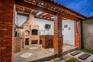 an outdoor kitchen with a brick oven in a yard at Pousada Vale do Café in Bueno Brandão
