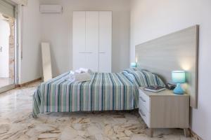 una camera bianca con letto e comodino di Casa Liliana 1 a Cava dʼAliga