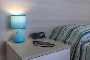 una lampada blu seduta su un tavolo accanto a un letto di Casa Liliana 1 a Cava dʼAliga Altre 22 foto