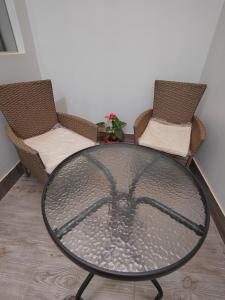 una mesa de cristal con 2 sillas en una habitación en Plaza Chicama, en Puerto Chicama