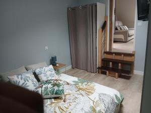 a bedroom with a bed and a door to a hallway at Studio de la Maison Bleue in Lanvallay