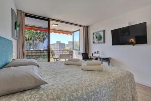 Un dormitorio con una cama grande con una ventana grande. en Sunset Tenerife, en Playa de las Américas