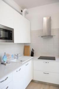 a white kitchen with white cabinets and a sink at Cinema Suite in Santa Margherita Ligure +18 photos