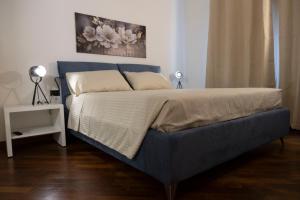 a bedroom with a blue bed with a painting on the wall at Cinema Suite in Santa Margherita Ligure