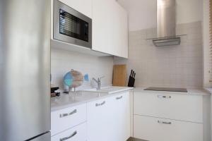 a white kitchen with white cabinets and a microwave at Cinema Suite in Santa Margherita Ligure