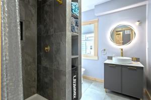 a bathroom with a sink and a shower with a mirror at Sea & Sun Cottage #3 in Hampton
