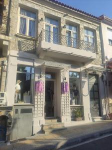 a store front of a white building with windows at Stonebuilt boutique apartment Levanda in Kymi +13 photos